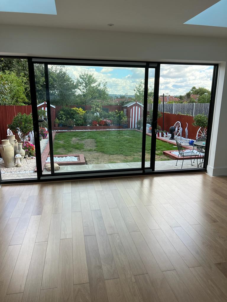 Modern house extension with sliding glass doors overlooking a beautiful garden